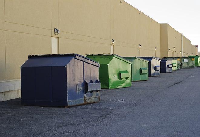 a row of yellow and blue dumpsters at a construction site in Mayfield, OH